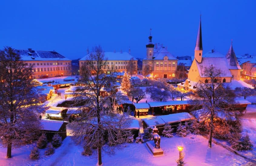 Schneebedeckter Marktplatz mit Weihnachtsmarkt