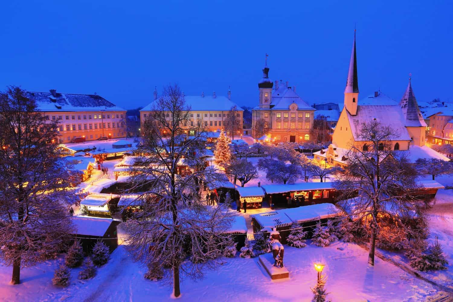 Schneebedeckter Marktplatz mit Weihnachtsmarkt