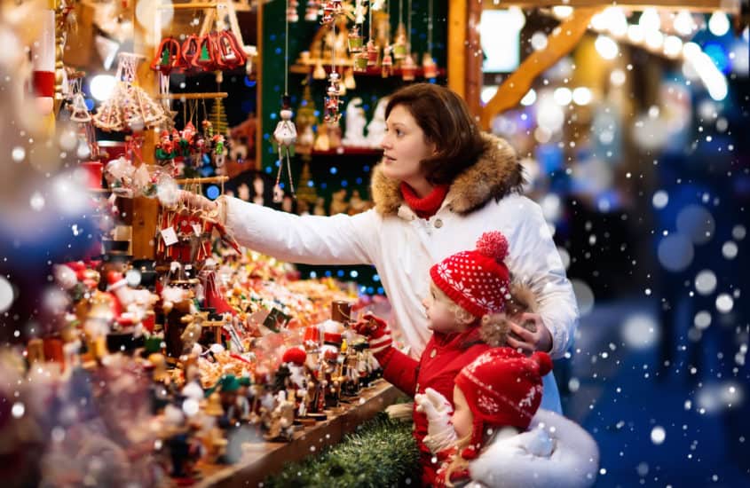Mutter und Kind stehen vor einer Weihnachtsmarkt Verkaufsbude