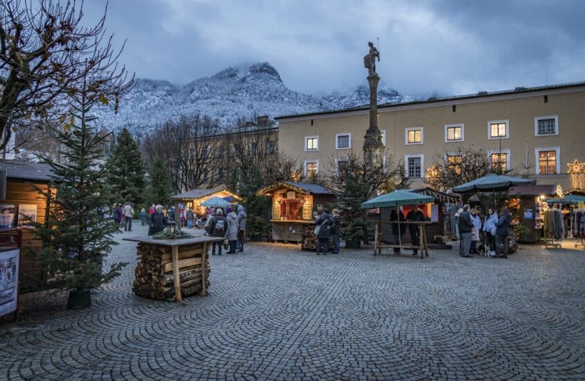 Weihnachtsmarkt in Bad Reichenhall vor verschneiter Alpenkulisse