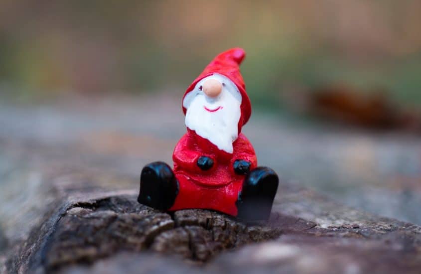 Weihnachtsmann Figur sitzt in Wald