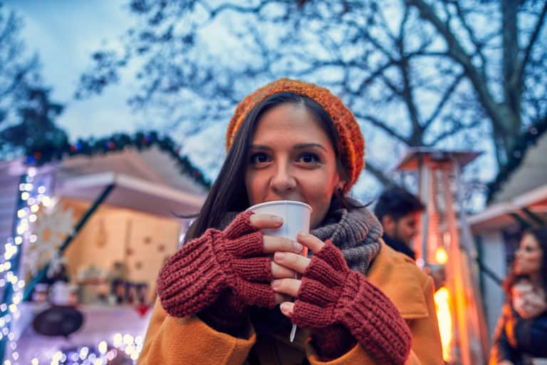 Dame trinkt Glühwein auf dem Weihnachtsmarkt