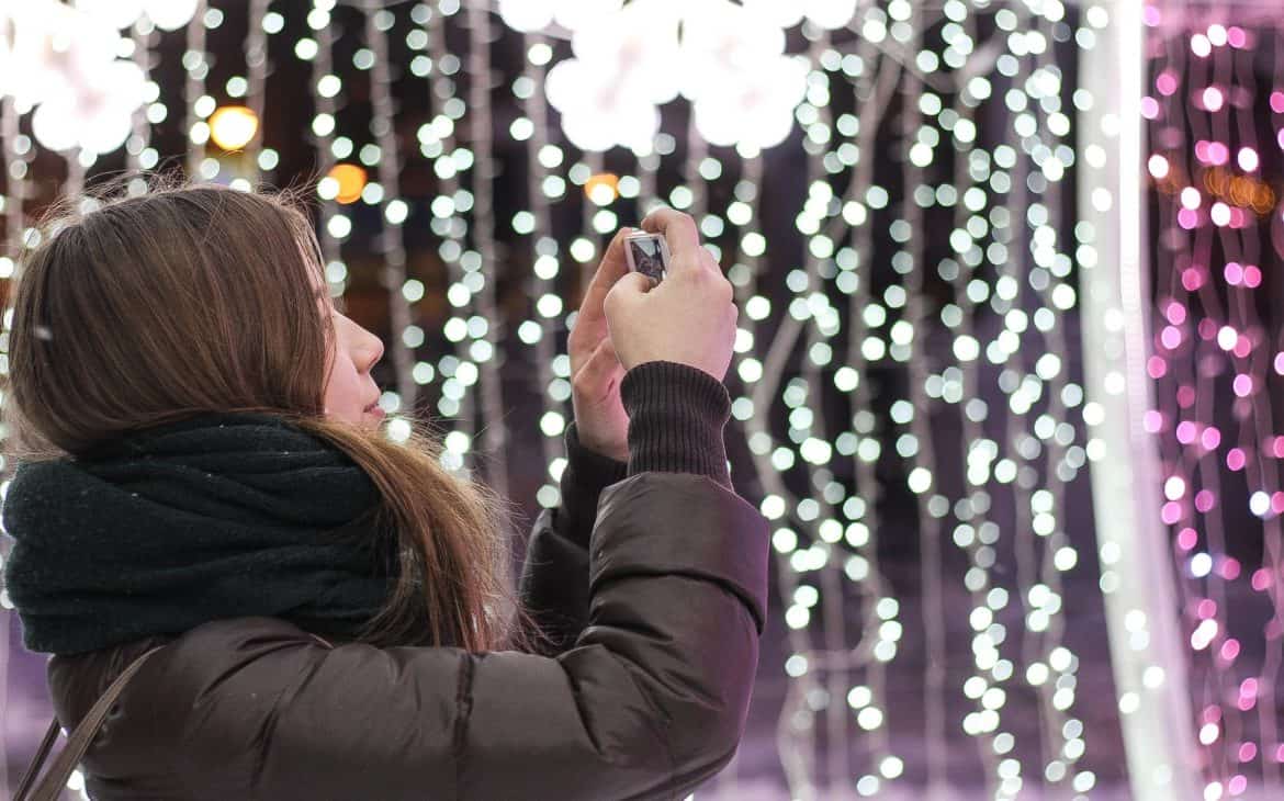 Mädel spielt mit der Weihnachtsbeleuchtung