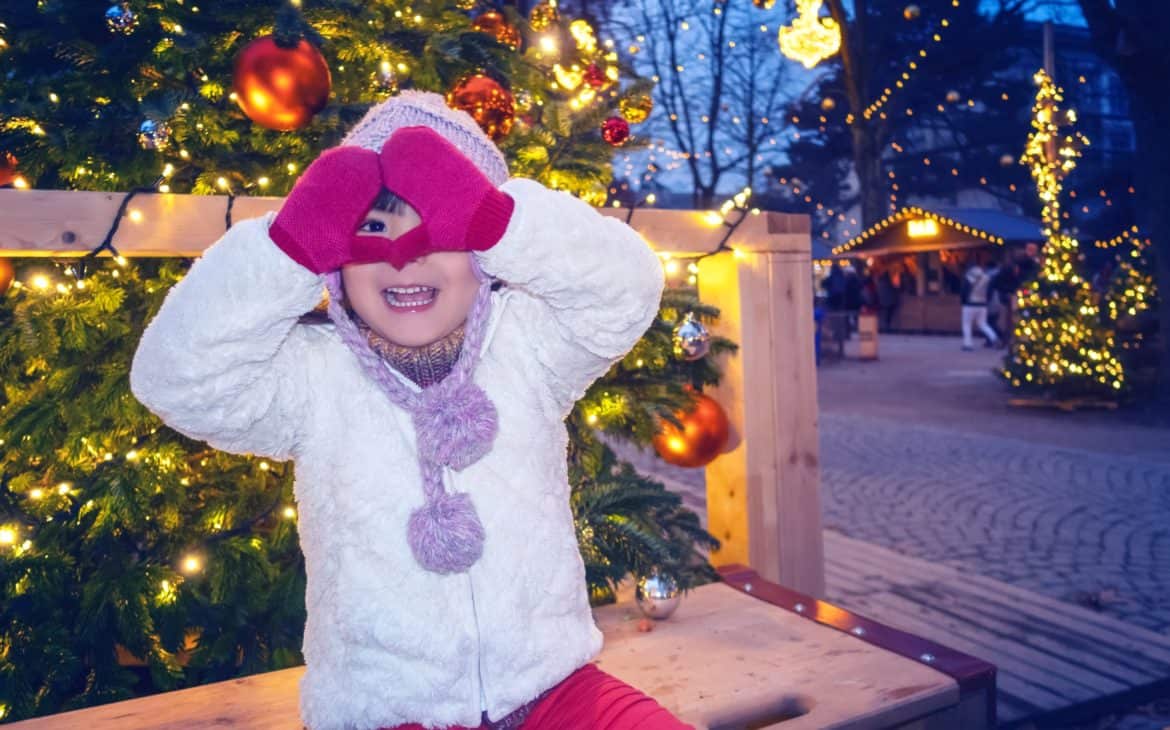 Kind fröhlich auf dem Weihnachtsmarkt