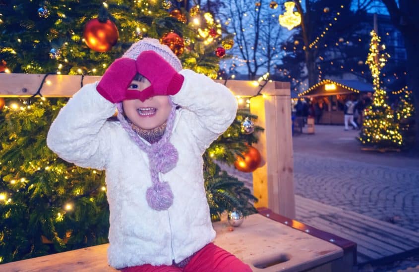 Kind fröhlich auf dem Weihnachtsmarkt