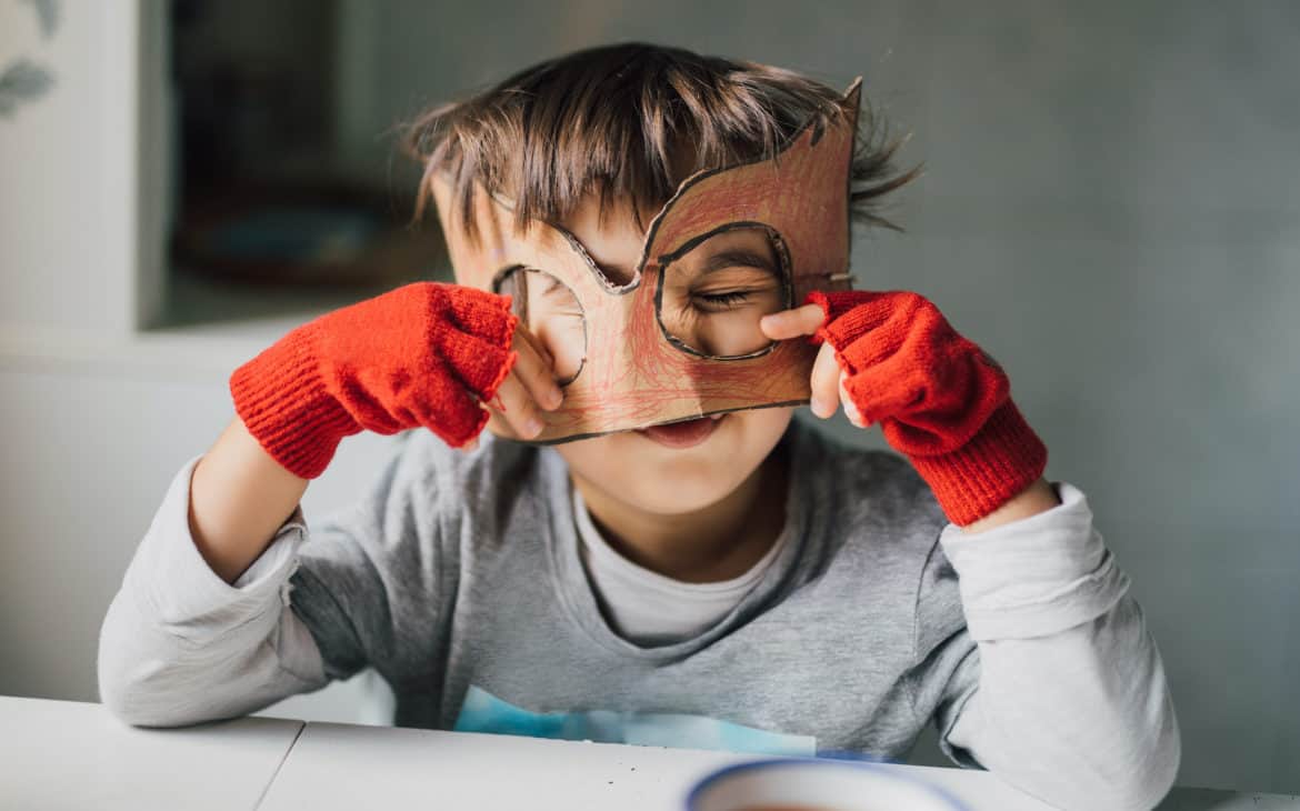 Kind mit selbstgebastelter Superhelden-Maske