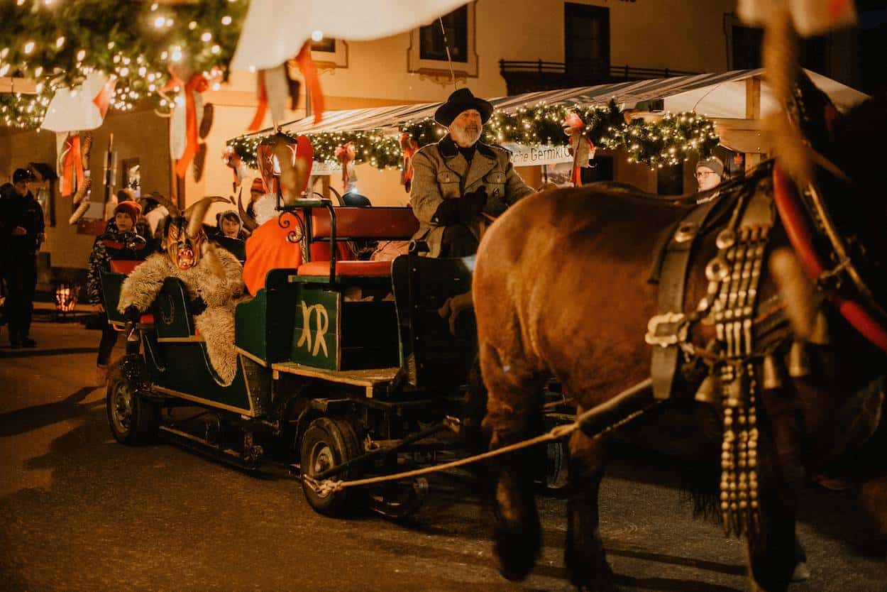 Eine festliche Pferdekutsche, die über den stimmungsvollen Weihnachtsmarkt von Bramberg am Wildkogel fährt.