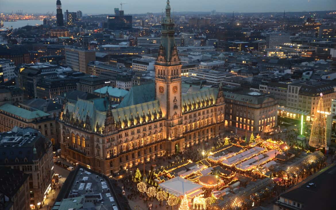 Blick von oben auf dem Rathausmarkt in Hamburg, das Rathaus und die erleuchteten und geschmückten Hütten des Weihnachtsmarktes.