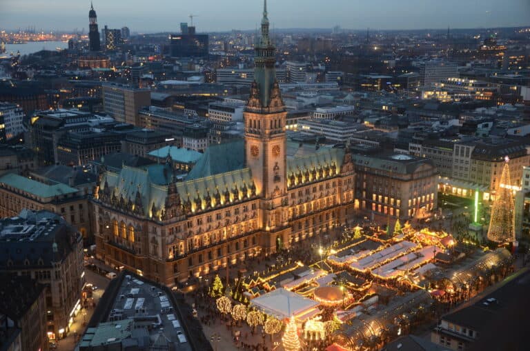 Blick von oben auf dem Rathausmarkt in Hamburg, das Rathaus und die erleuchteten und geschmückten Hütten des Weihnachtsmarktes.