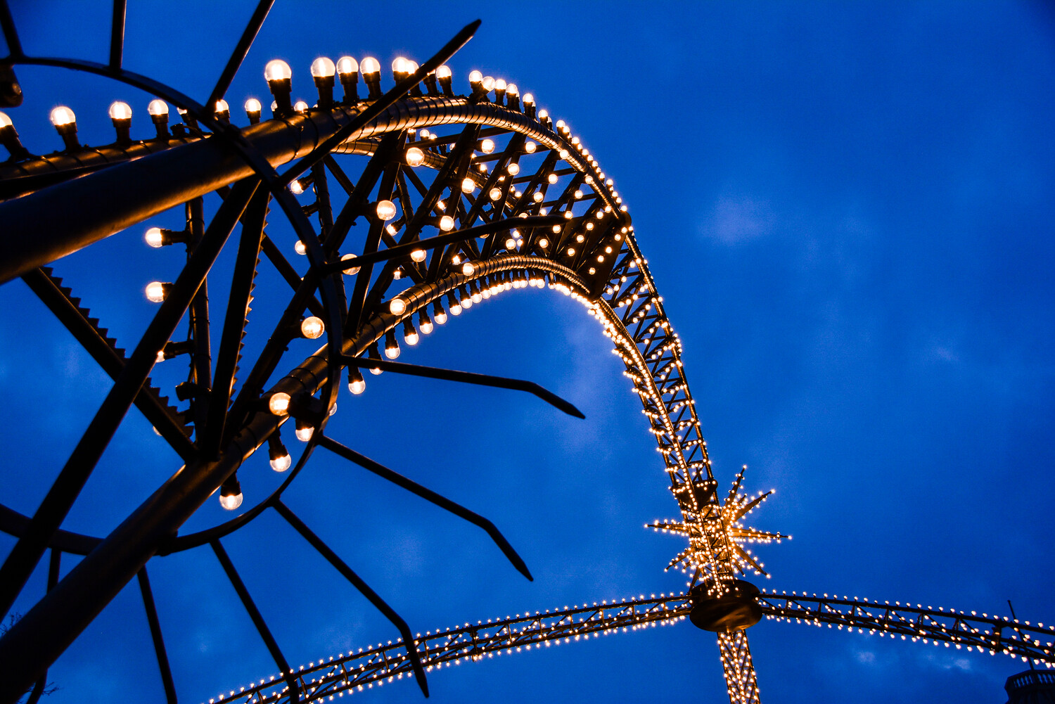 In der abendlichen Dämmerung leuchten die Lichterbögen mit Sternen auf dem Kö-Lichter-Markt in Düsseldorf hell.