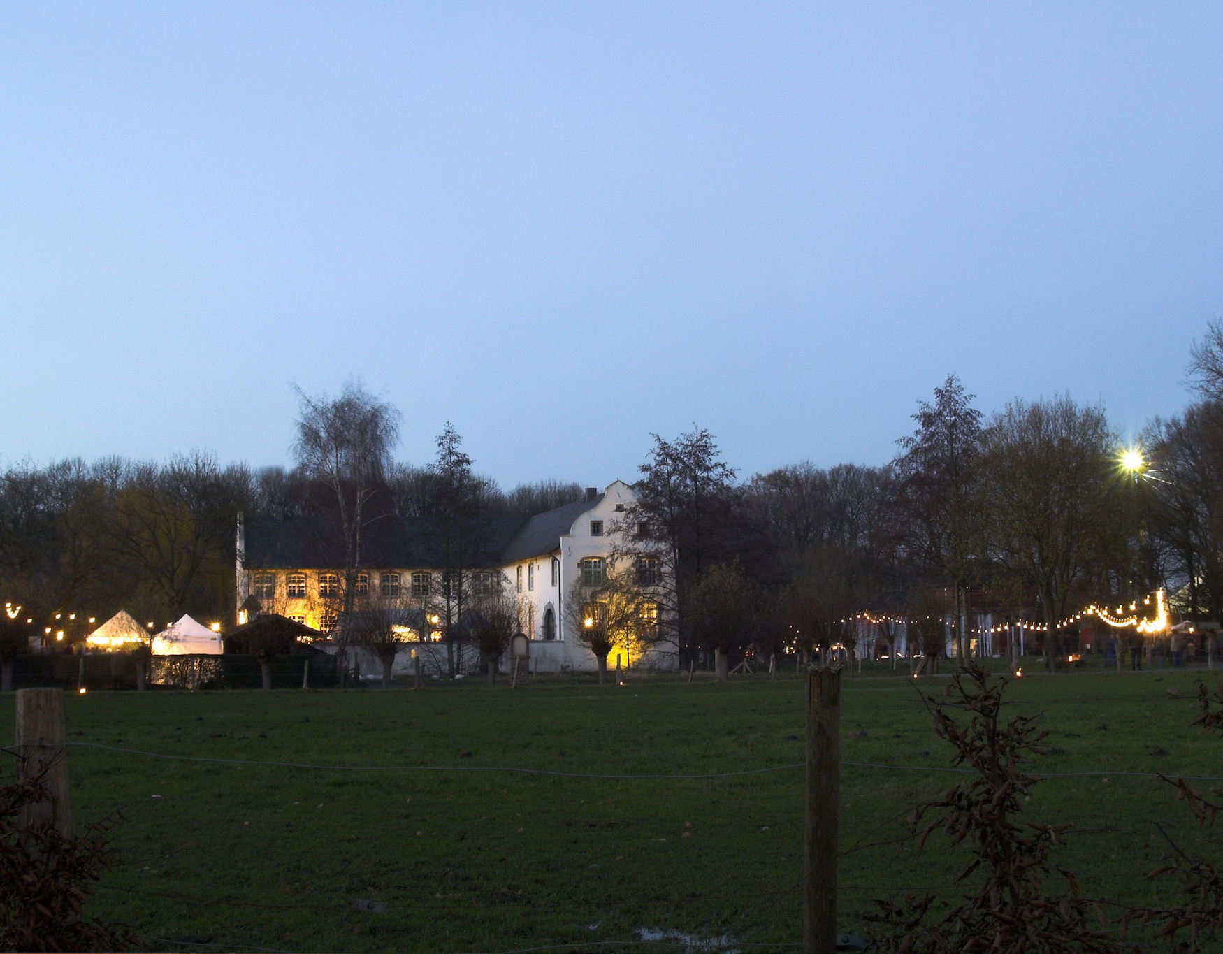 Blick auf das mit Lichtern geschmückte Wasserschloss Dorenburg in Grefrath.