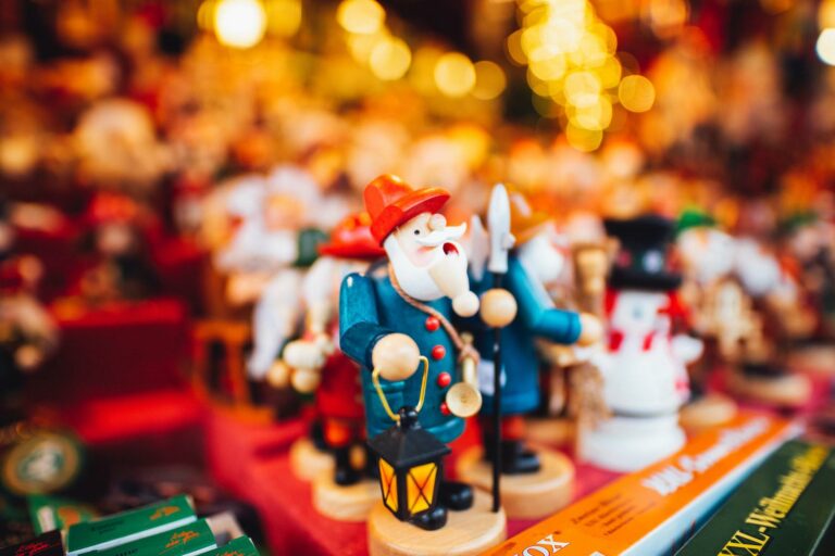 Ein buntes Räuchermännchen aus Holz mit Laterne in der Hand steht in einem Stand auf dem Weihnachtsmarkt.