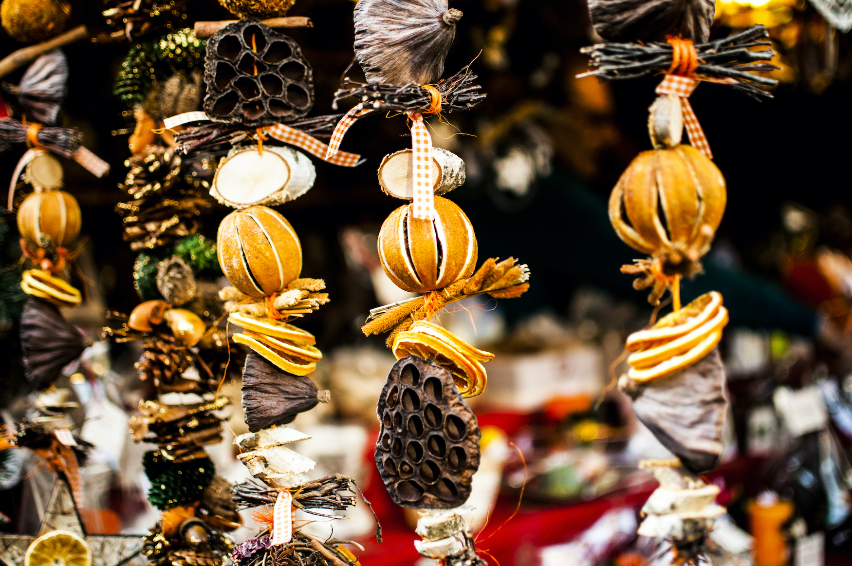 Weihnachtsschmuck aus Orangen und anderen Elementen aus der Natur hängen an einem Stand auf dem Weihnachtsmarkt.