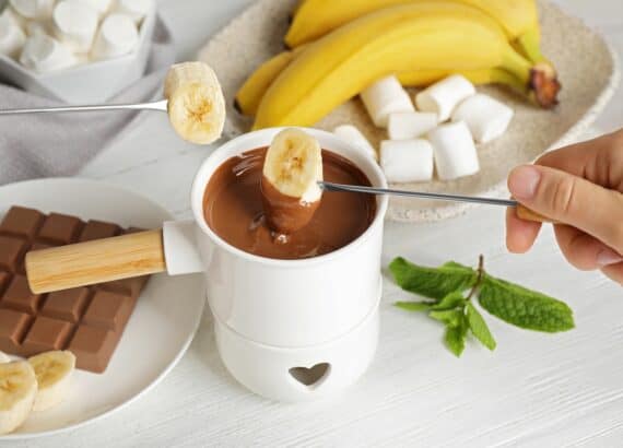 Banane wird in Schokoladenfondue gehalten