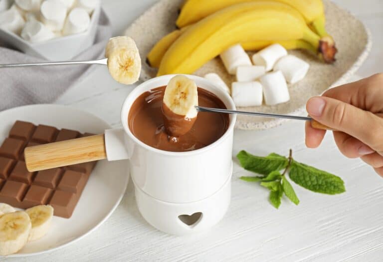Banane wird in Schokoladenfondue gehalten