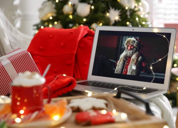 Weihnachtsfilm läuft auf Laptop bei gemütlicher Weihnachtsatmosphäre