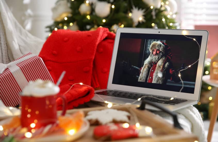 Weihnachtsfilm läuft auf Laptop bei gemütlicher Weihnachtsatmosphäre