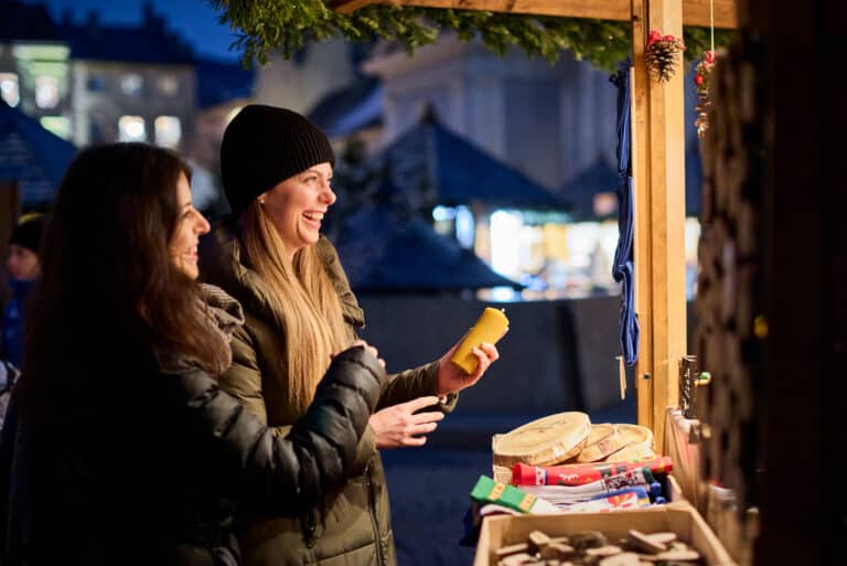 Zwei fröhliche Frauen stehen am Kunsthandwerkstand