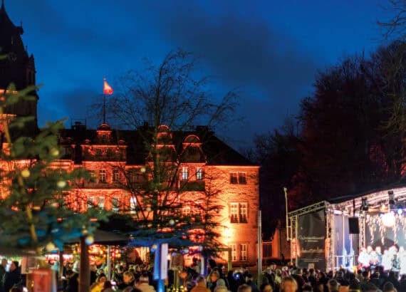 Weihnachtsmarkt vor dem erleuchteten Schloss in Detmold