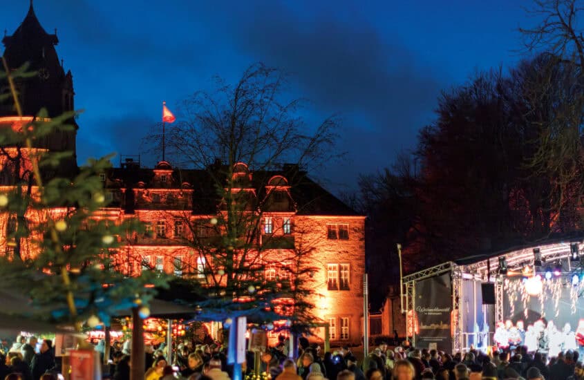 Weihnachtsmarkt vor dem erleuchteten Schloss in Detmold