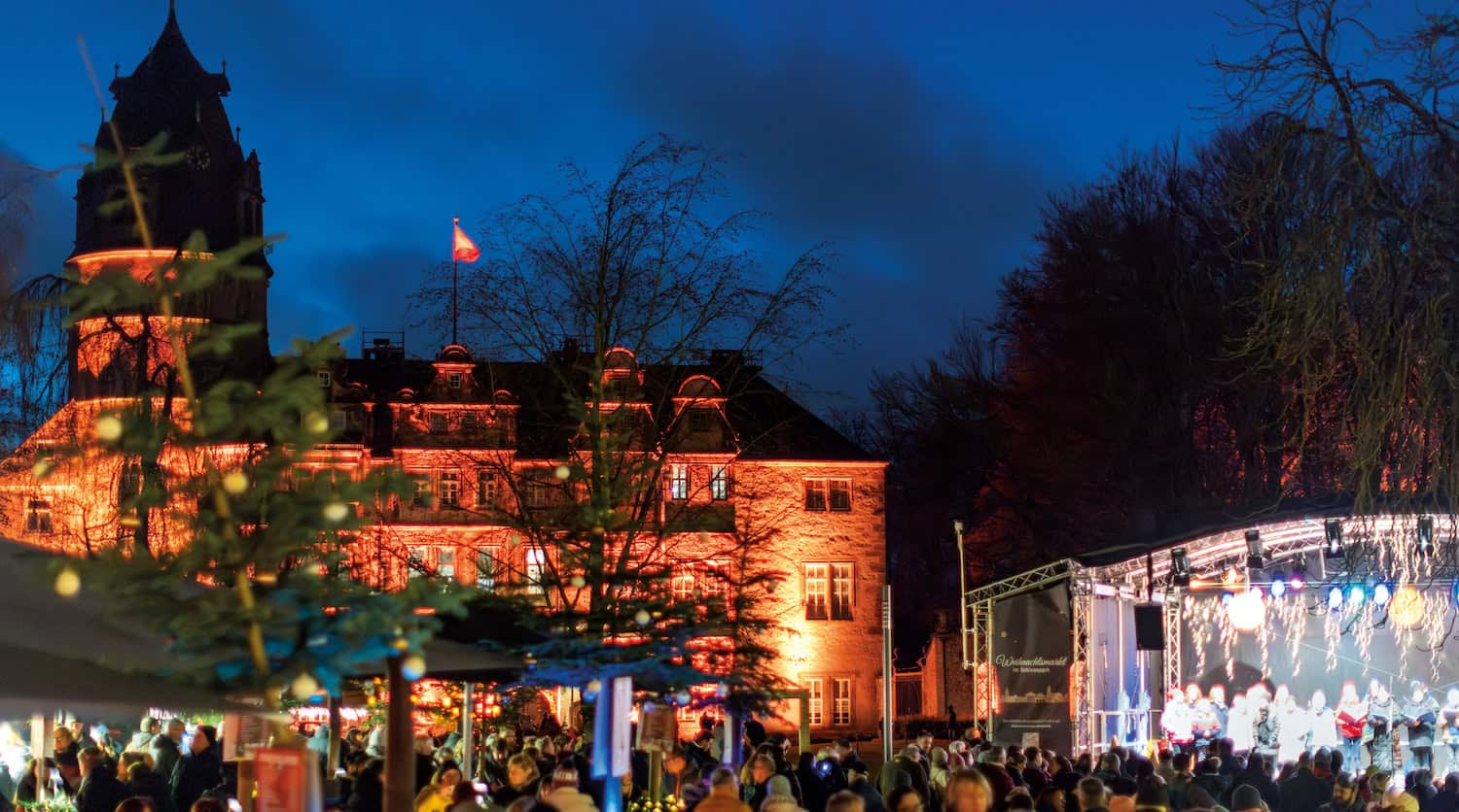 Weihnachtsmarkt vor dem erleuchteten Schloss in Detmold