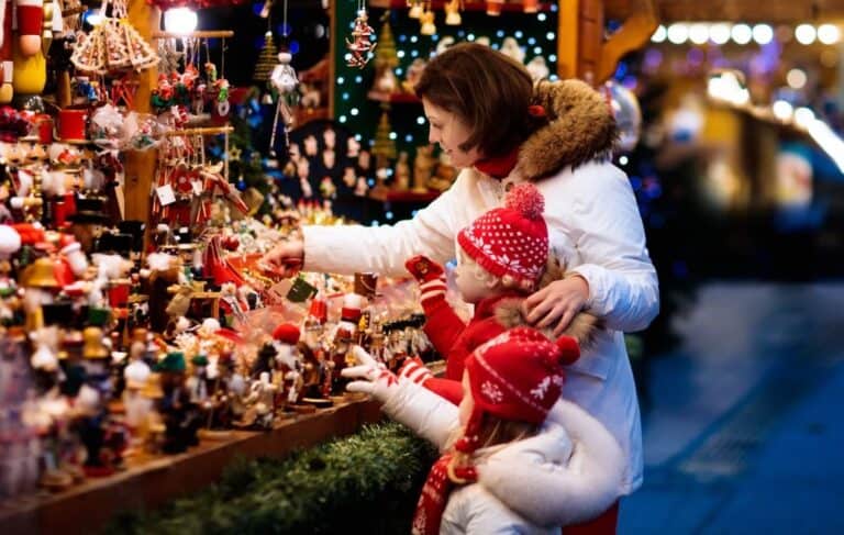 Frau und Kind bewundern Spielfiguren auf dem Weihnachtsmarkt Westfield Überseequartier Hamburg shutterstock.com