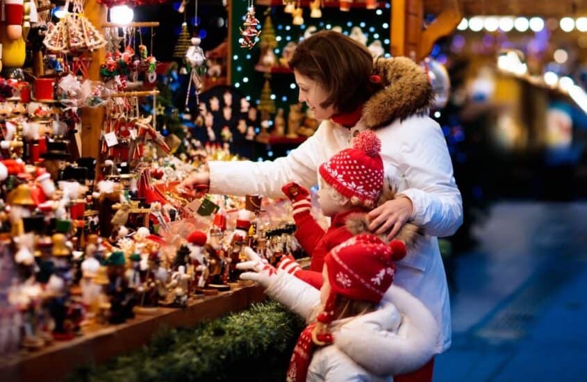 Frau und Kind bewundern Spielfiguren auf dem Weihnachtsmarkt Westfield Überseequartier Hamburg shutterstock.com