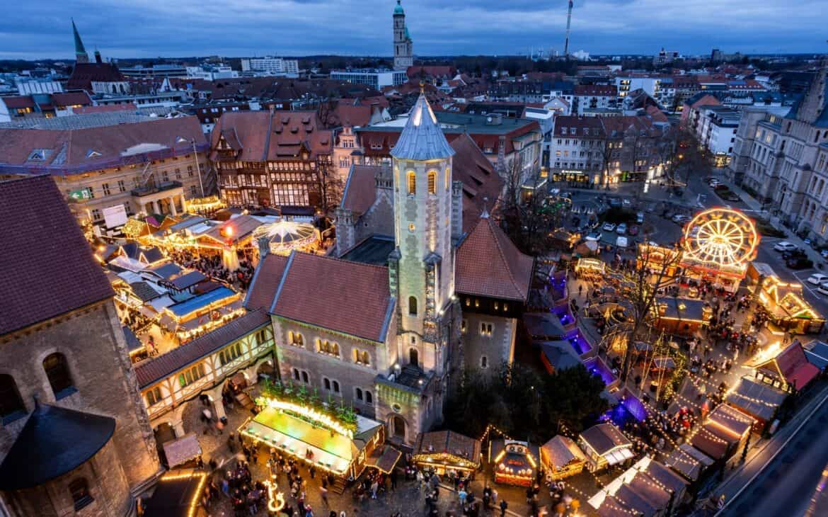 Weihnachtsmarkt Braunschweig von oben in der Abenddämmerung mit beleuchteter Burg Dankwarderode, Dom St. Blasii, Riesenrad, Karussell und Buden