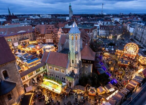 Weihnachtsmarkt Braunschweig von oben in der Abenddämmerung mit beleuchteter Burg Dankwarderode, Dom St. Blasii, Riesenrad, Karussell und Buden