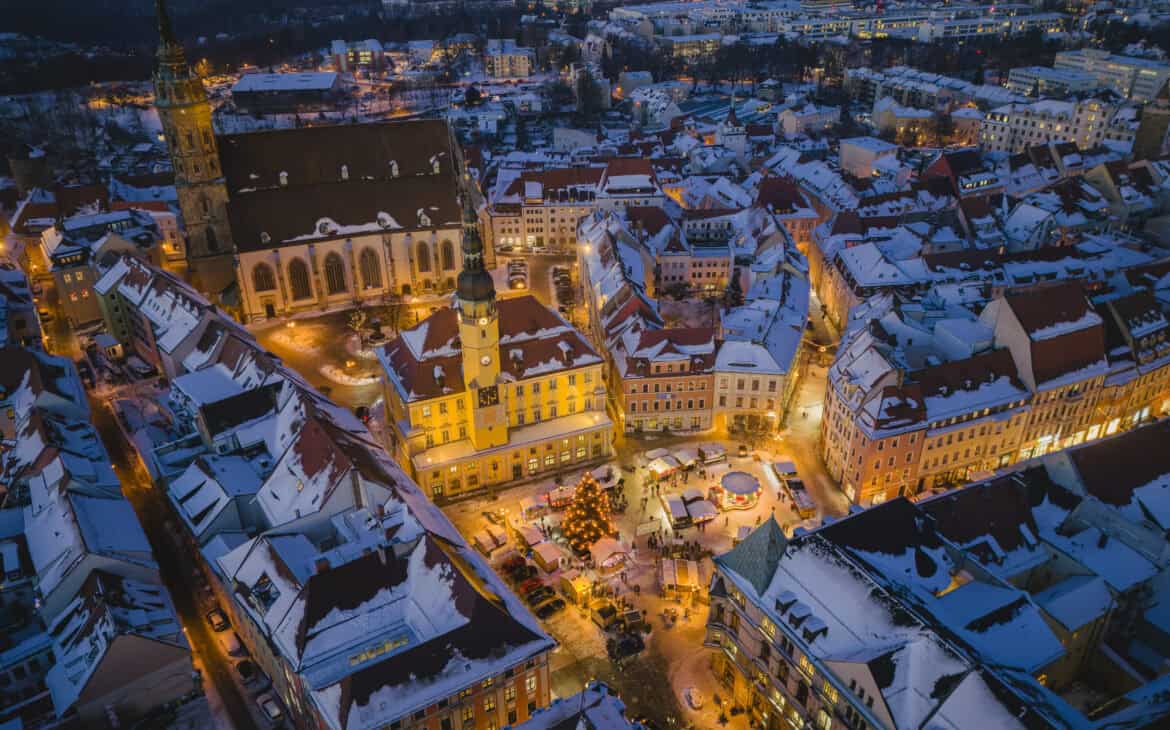 Verschneite Altstadt von Bautzen zur blauen Stunde aus der Luft, mit beleuchtetem Rathaus, Dom St. Petri und dem Wenzelsmarkt mit Weihnachtsbaum auf dem Hauptmarkt