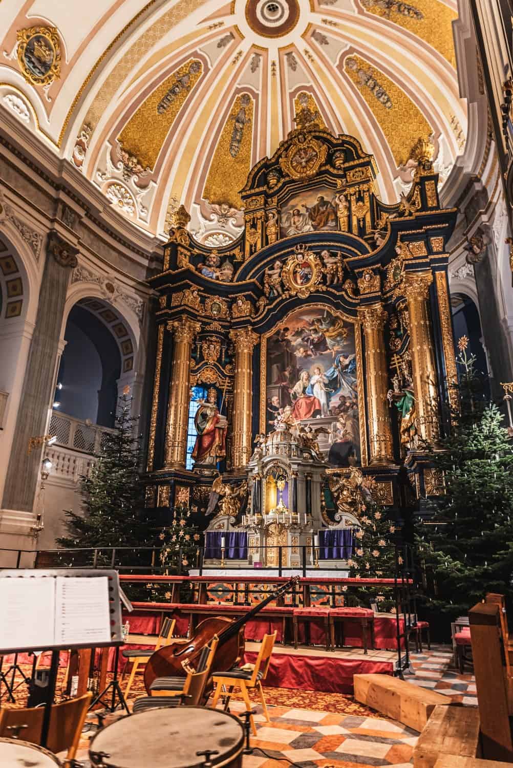 Barocker Hochaltar mit Weihnachtsbäumen und Konzertbestuhlung in der Basilika Altötting zur Adventszeit.